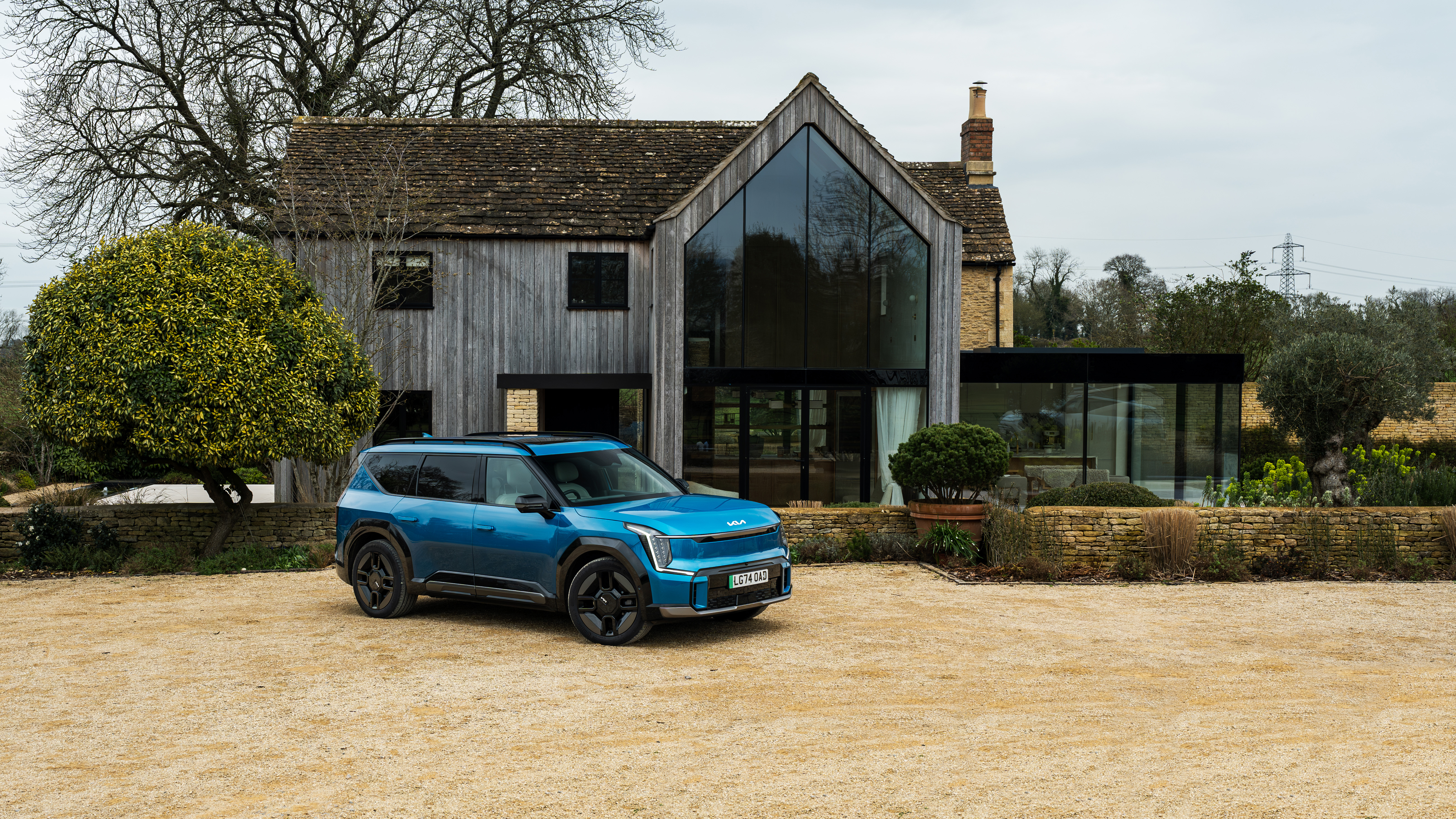 Kia EV9 parked in front of a modern-looking house