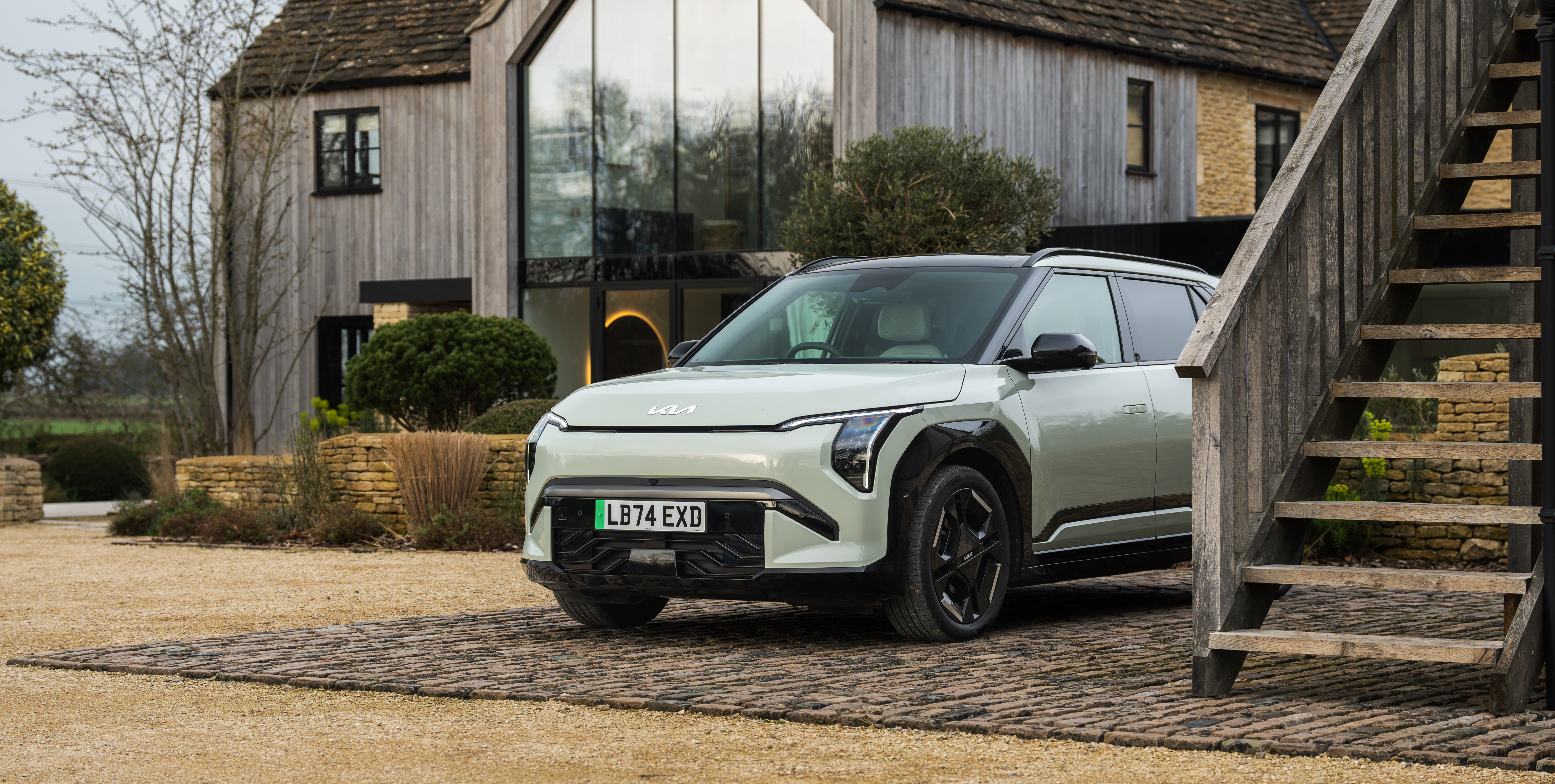 Kia EV3 in pistachio green outside a modern-looking house