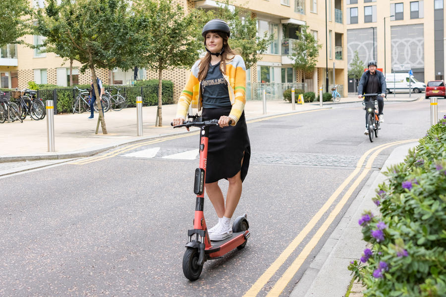 Woman riding e-scooter in road