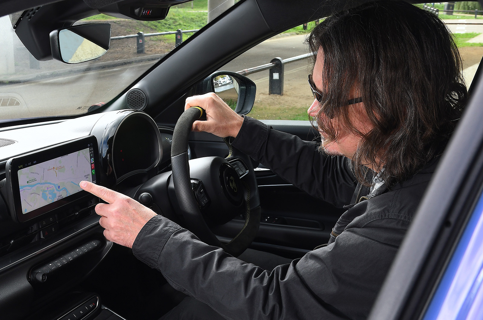 Abarth 600e Mark prodding touchscreen
