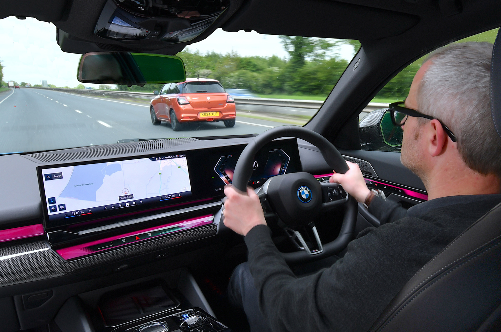 BMW i5 LT interior over the shoulder of driver on a dual carriageway