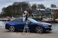 bmw_i5_lt_with_person_on_ladder_looking_through_binoculars