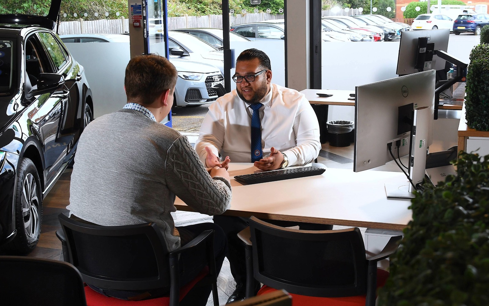 Customer and a salesperson discuss finance options inside a dealership