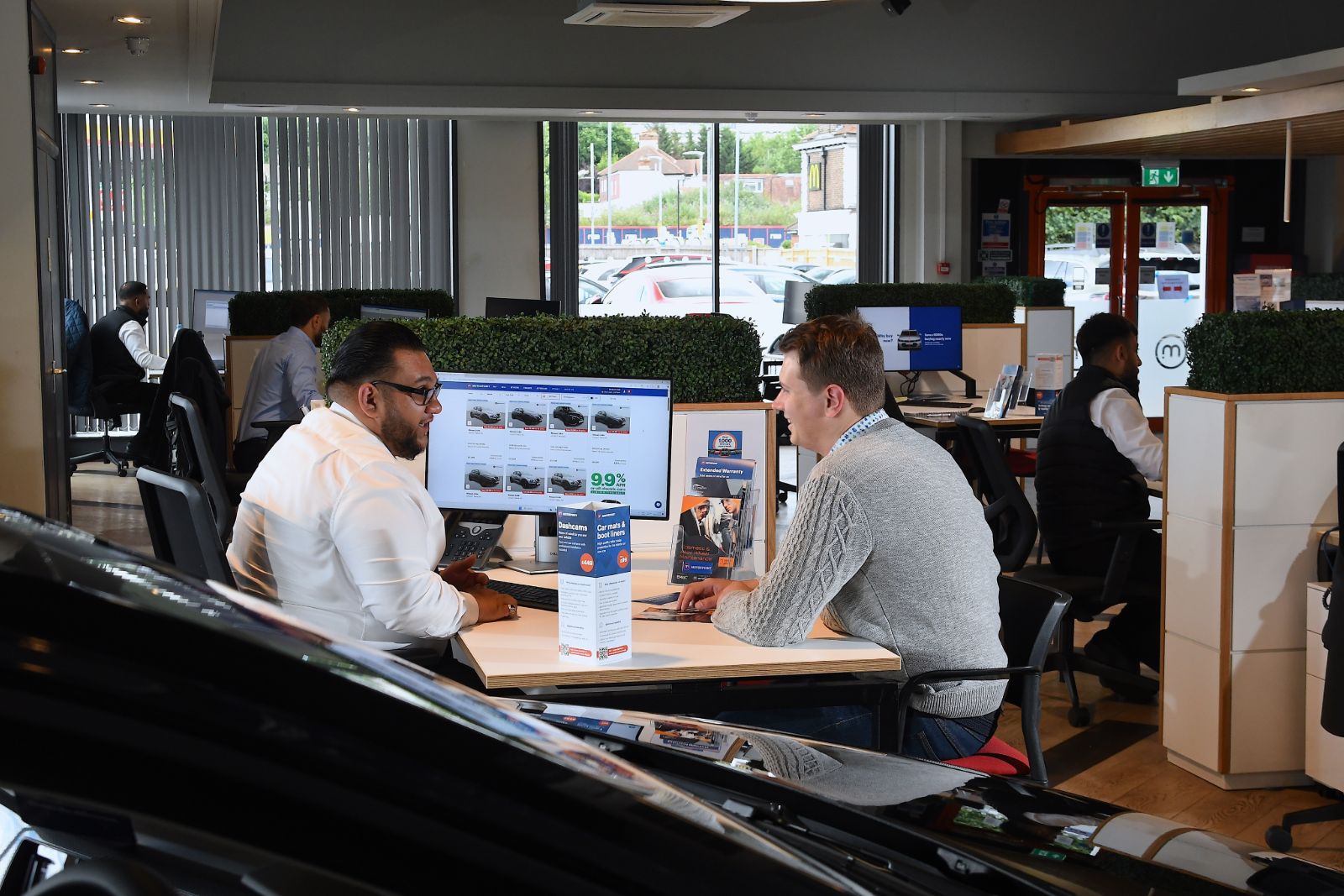 Customer and salesperson discuss financing options inside dealership