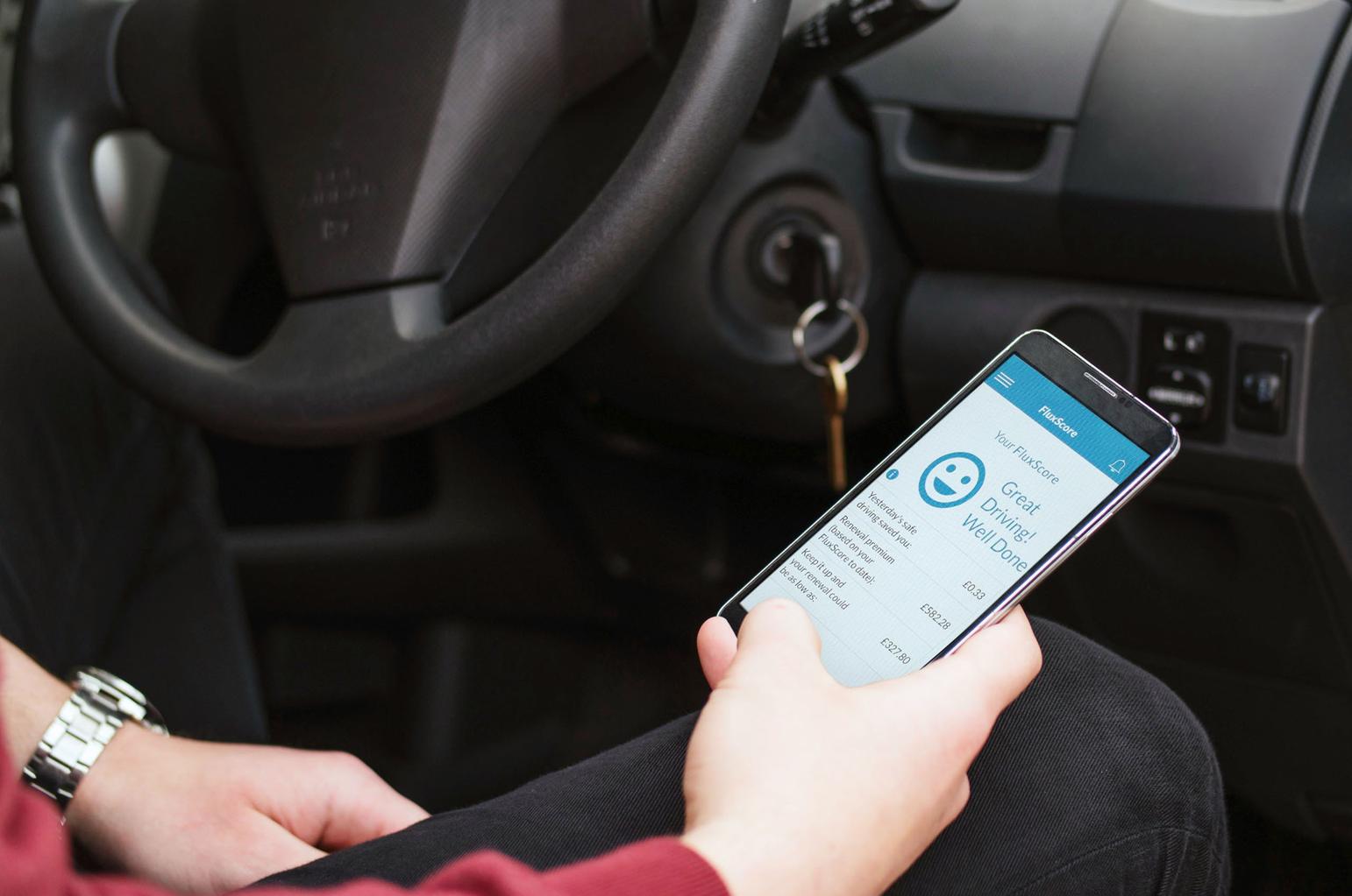 Driver checking smartphone black box insurance app