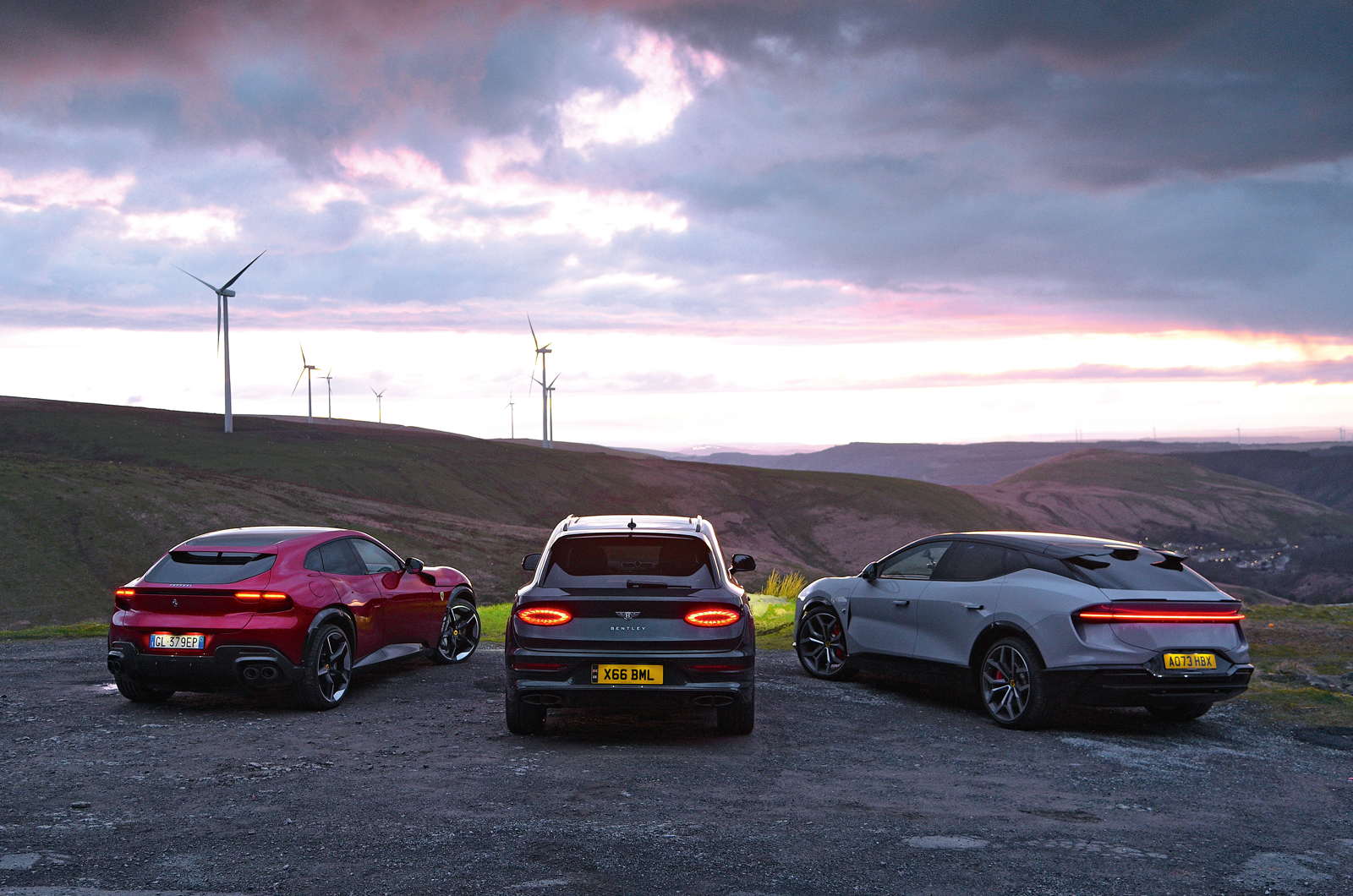 Ferrari Purosangue with Bentley Bentayga and Lotus Eletre rears at night