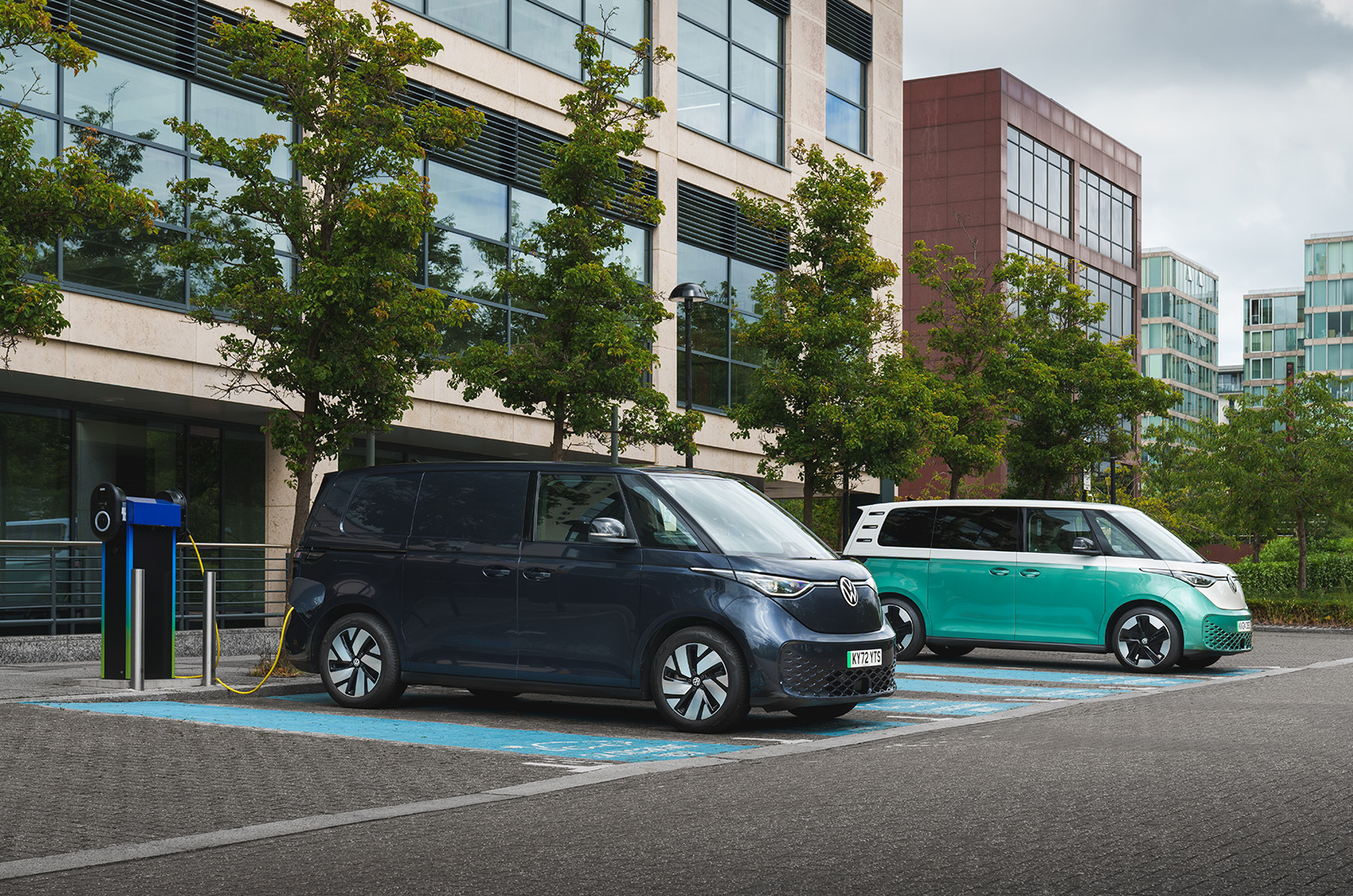 A dark blue Volkswagen ID. Buzz Cargo van is charging in a car park.