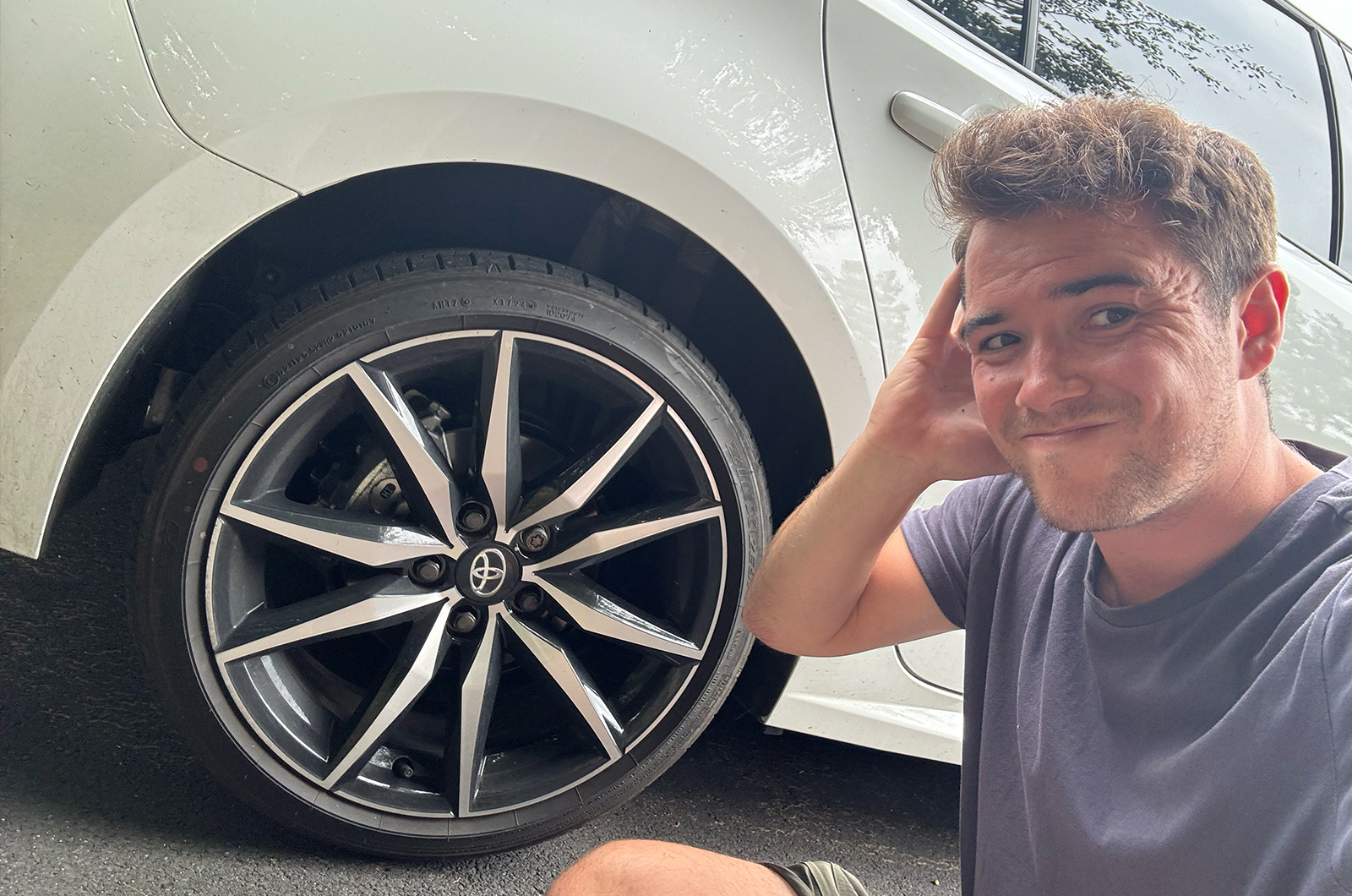Jonty looking concerned next to Toyota Corolla Touring Sports wheel