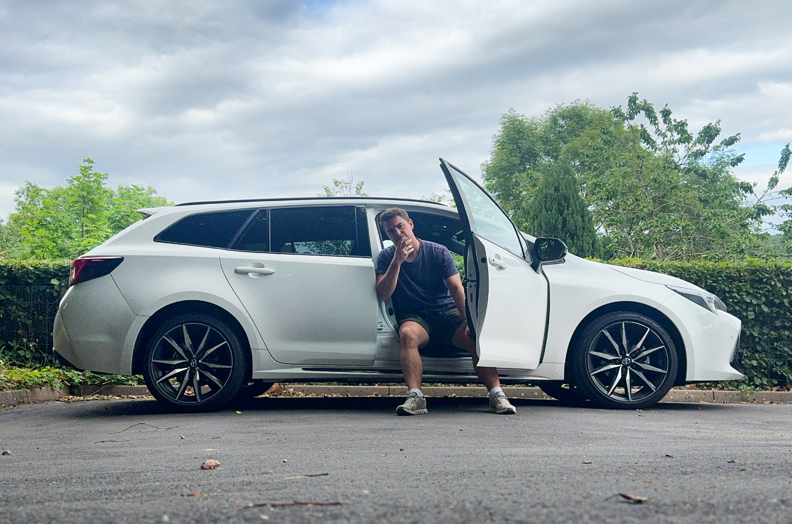 Jonty sitting on Toyota Corolla Touring Sports long-term test car looking concerned