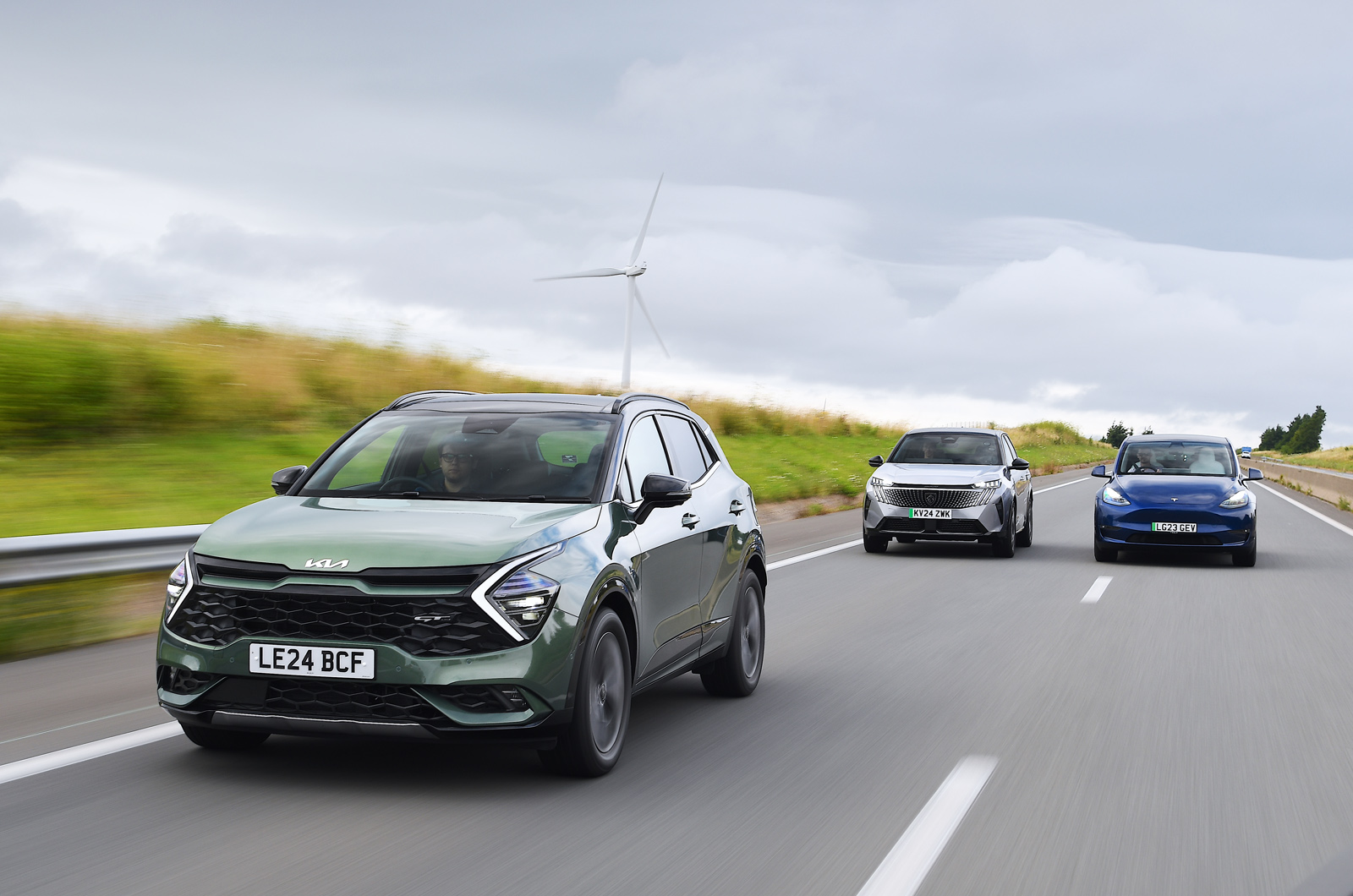 Kia Sportage vs Peugeot e-3008 vs Tesla Model Y on autoroute left fronts