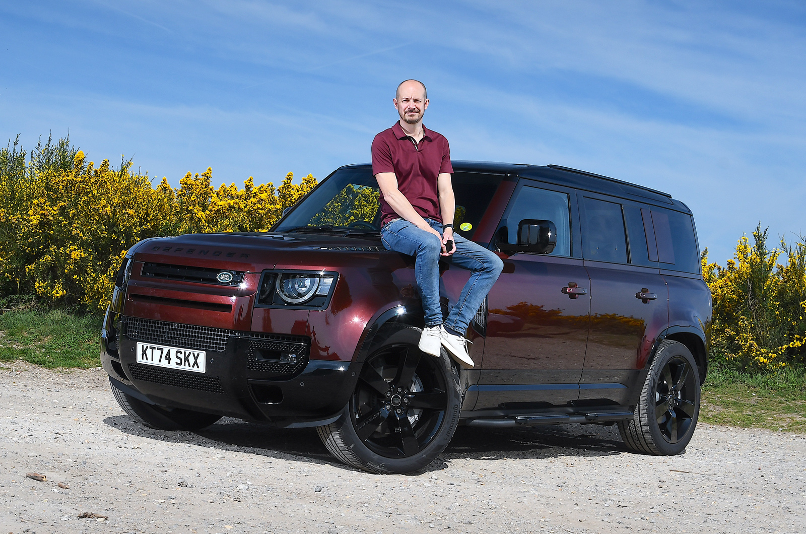 Land Rover Defender with person sitting on the bonnet