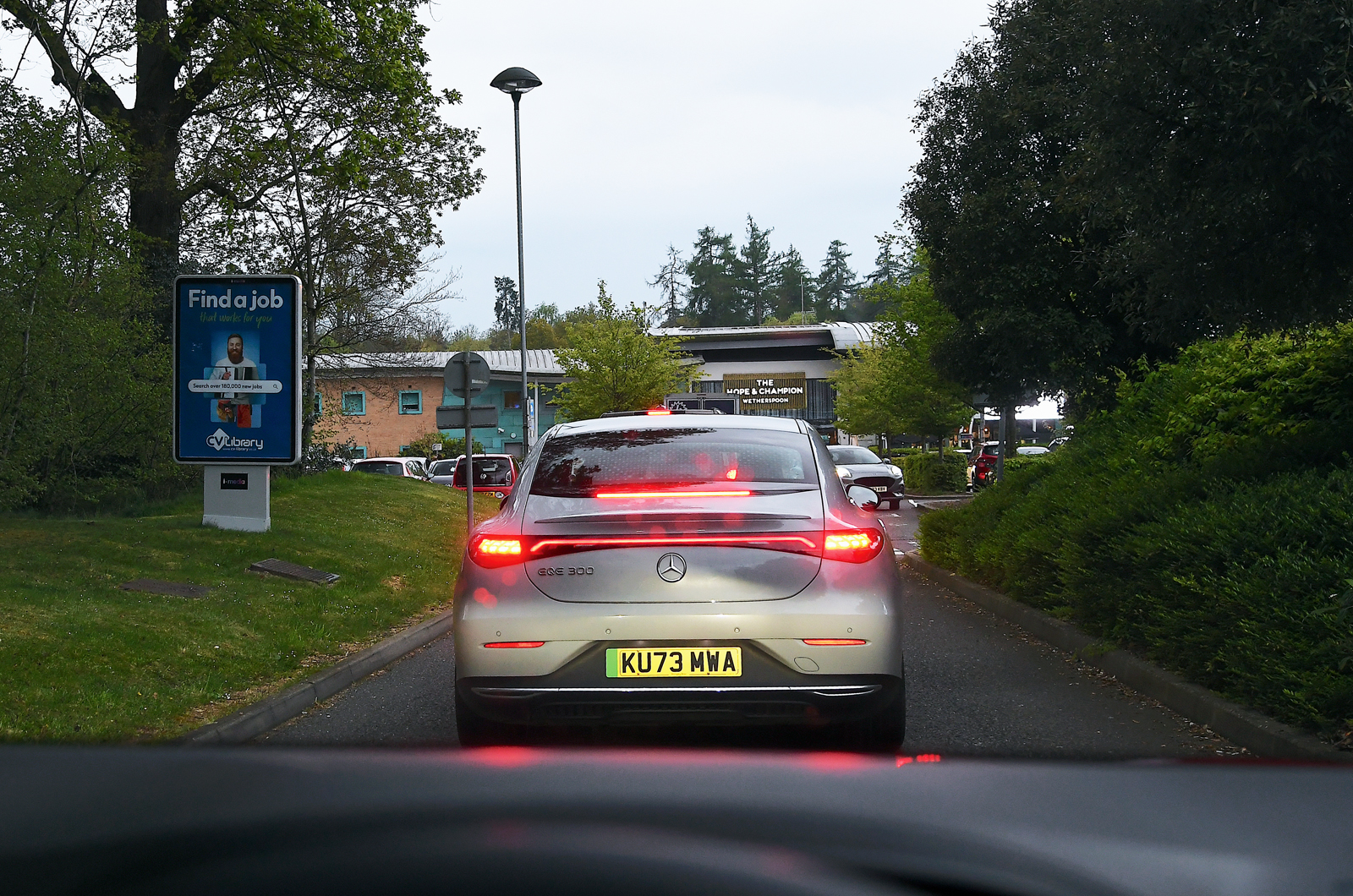 Mercedes EQE arriving at motorway service station