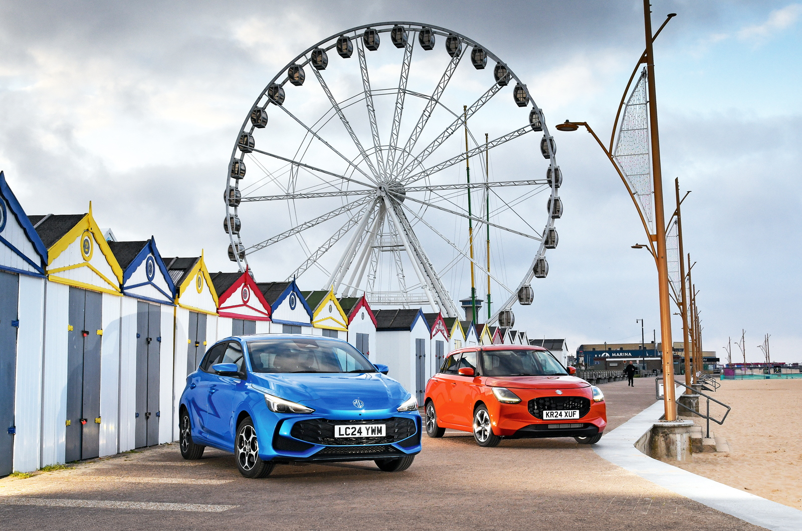 MG 3 and Suzuki Swift in front of fairground big wheel