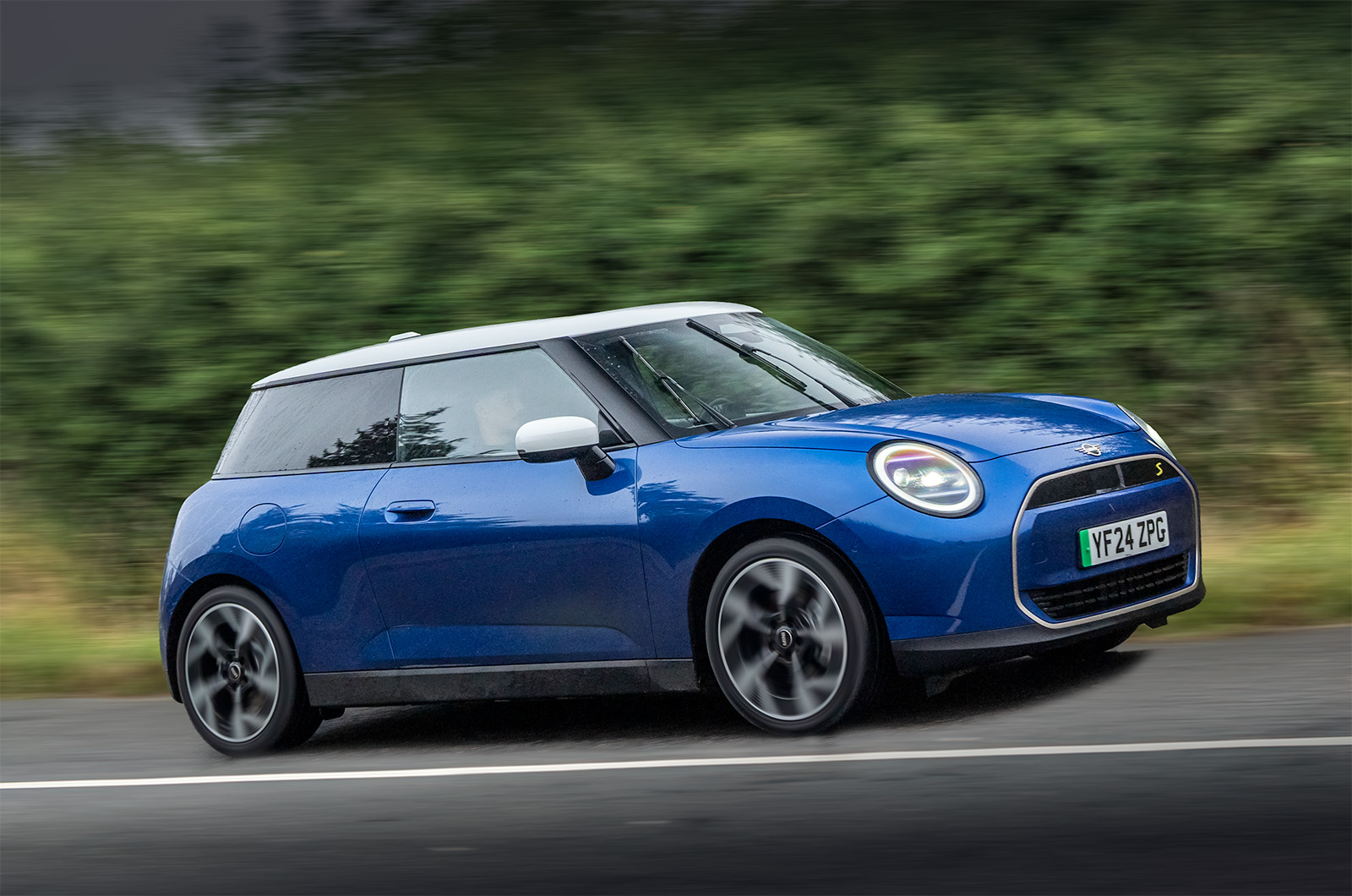 Blue MINI Cooper Electric driving on a country road
