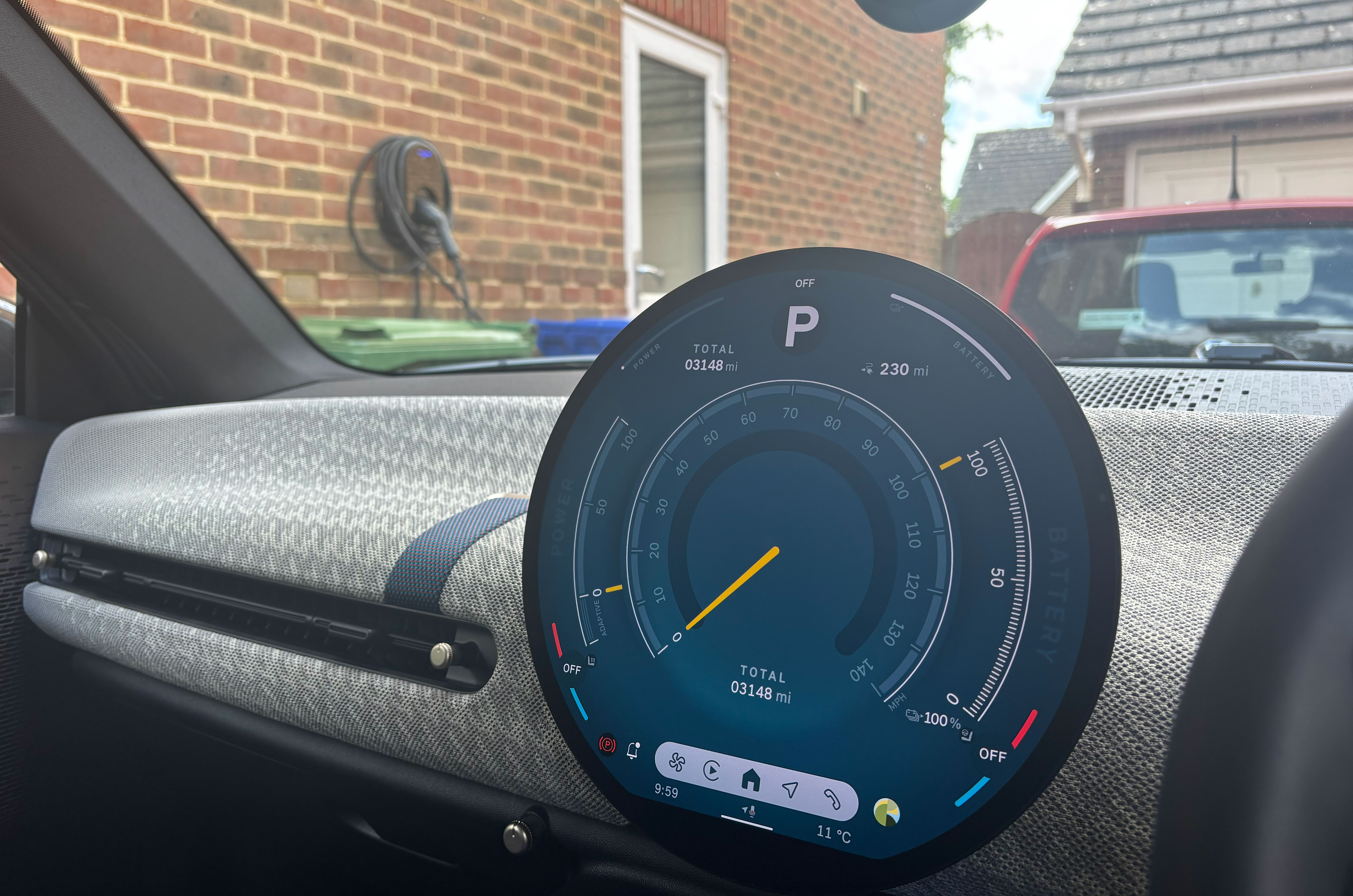 Mini Cooper SE fully charged with charger in background