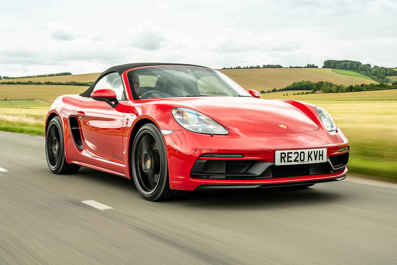Red Porsche 718 Boxster front right driving