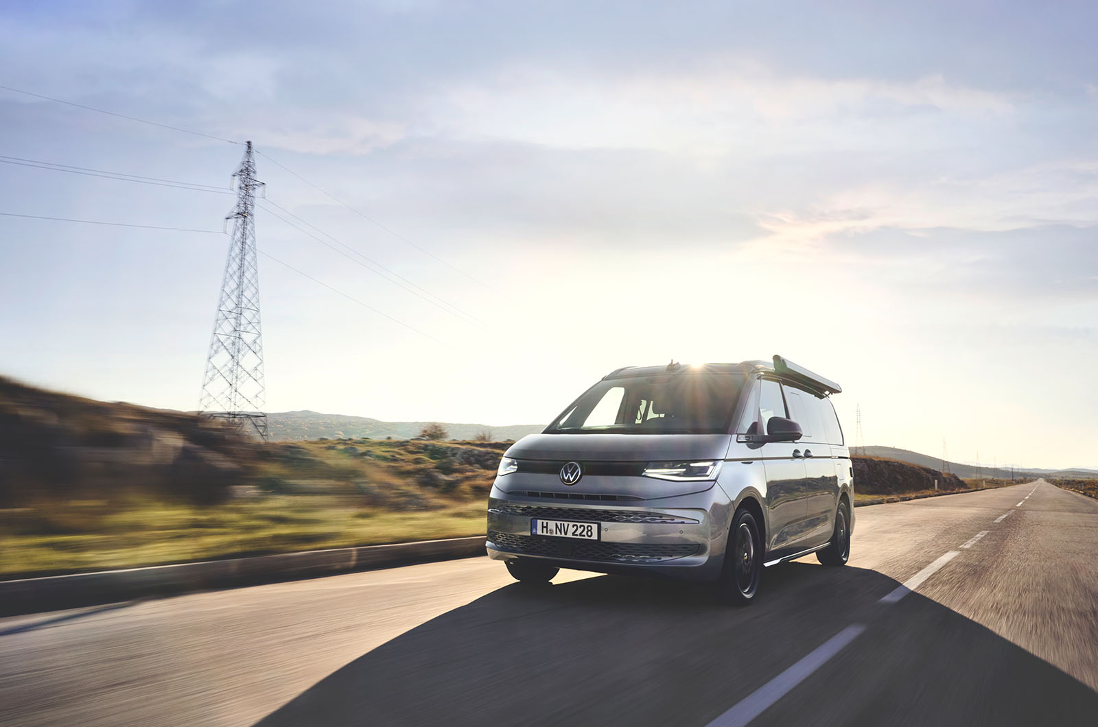 Front left quarter of a silver Volkswagen California driving on the road