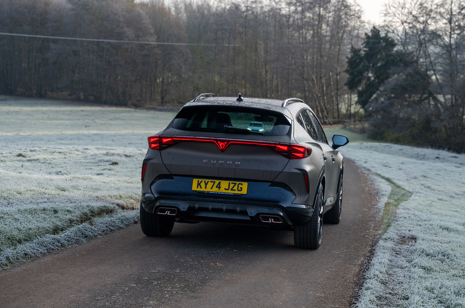 CUPRA Formentor driving on a country road viewed from the rear