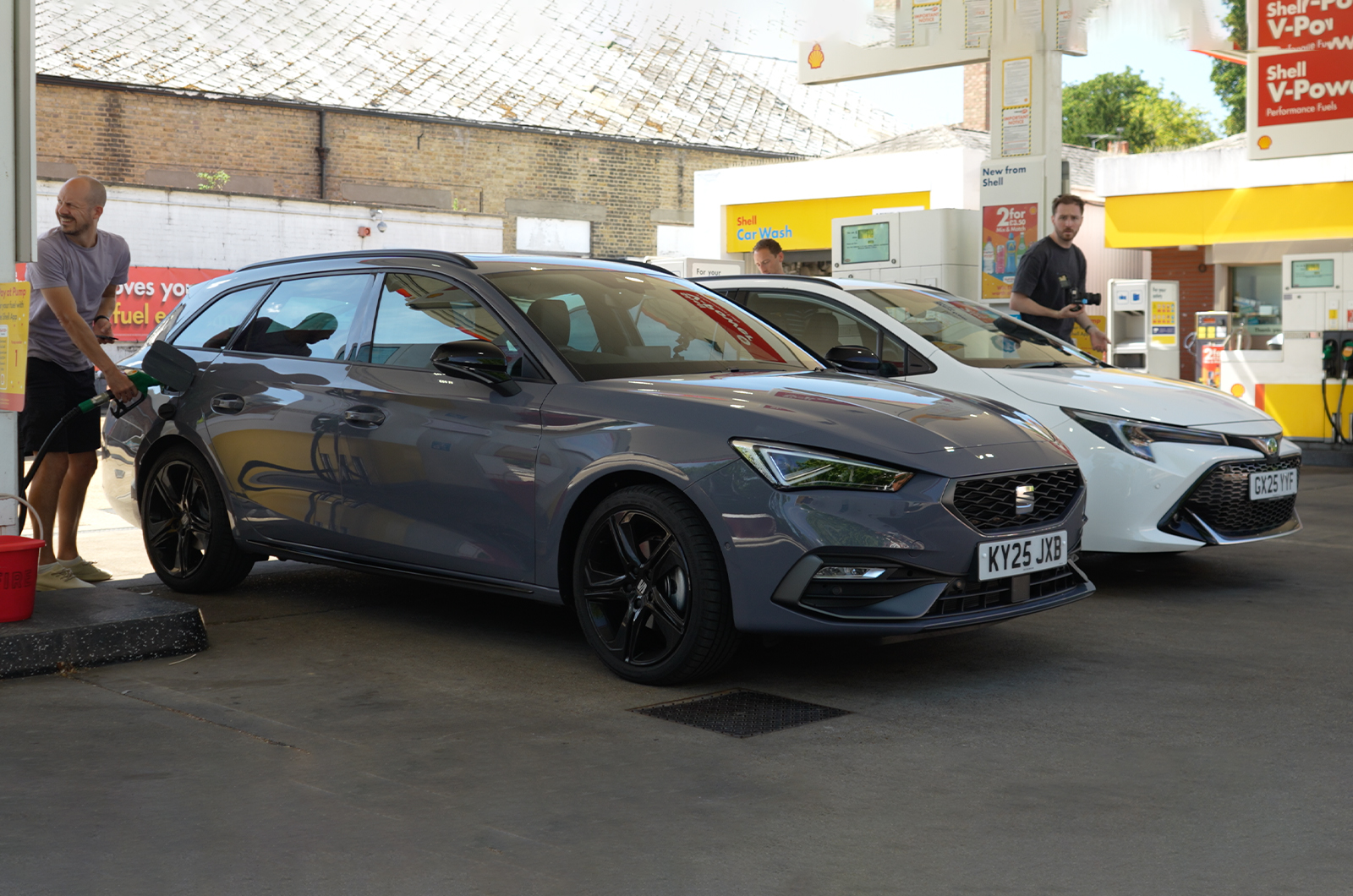 Seat Leon Estate parked next to Toyota Corolla Touring Sports at a petrol station