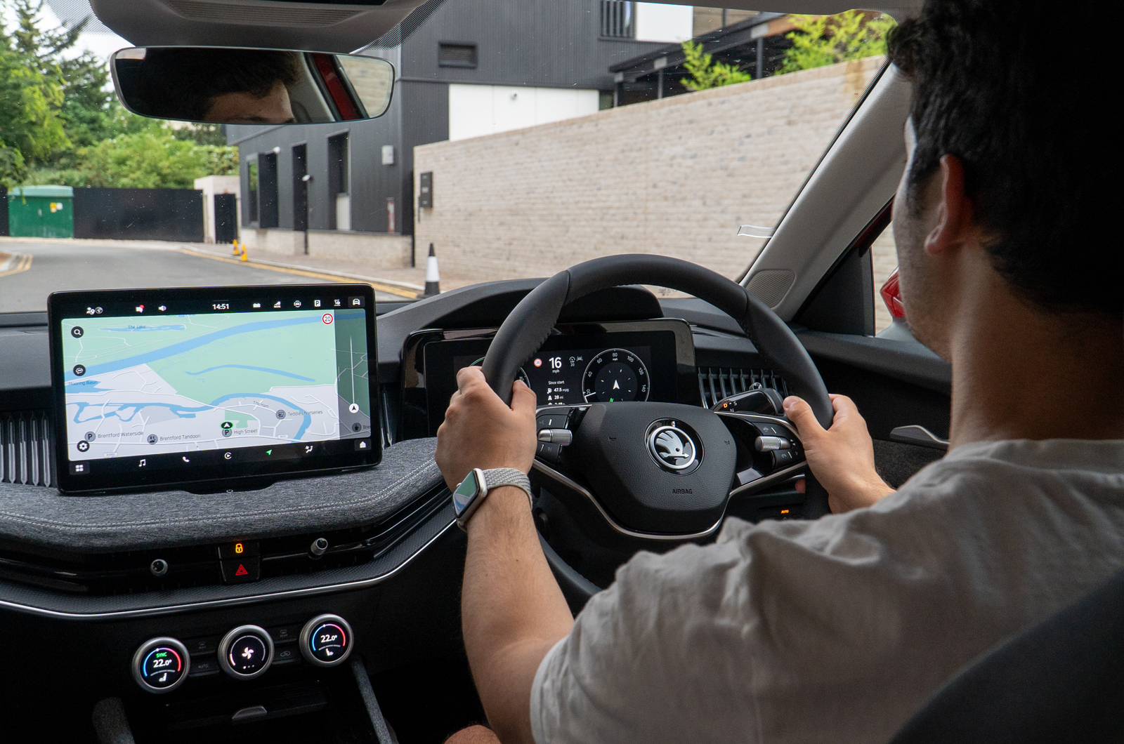 Interior driving shot of a driver's hands on the wheel of a Skoda Superb