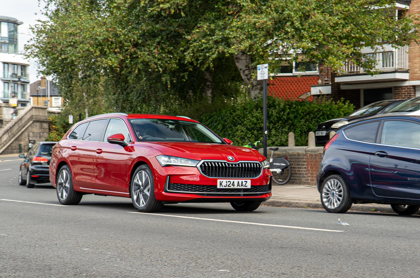 Front 3/4 on-the-road driving shot of a red Skoda Superb