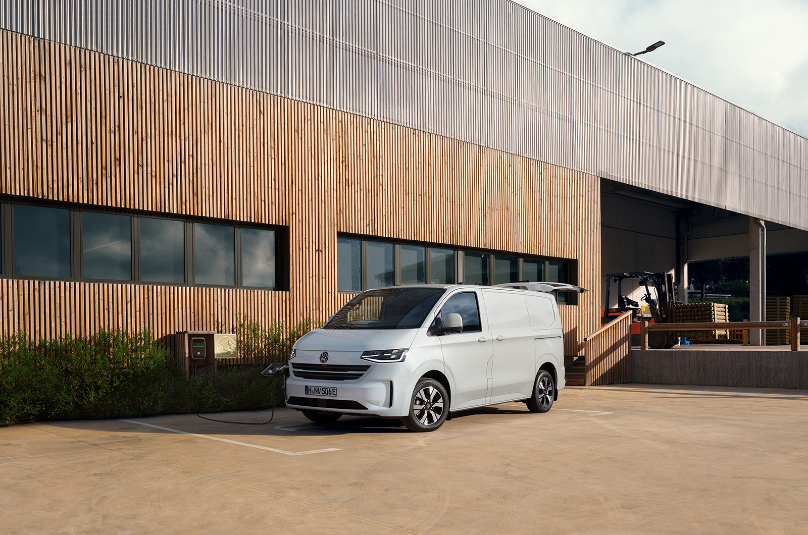 White Volkswagen Transporter parked in front of a modern-looking building