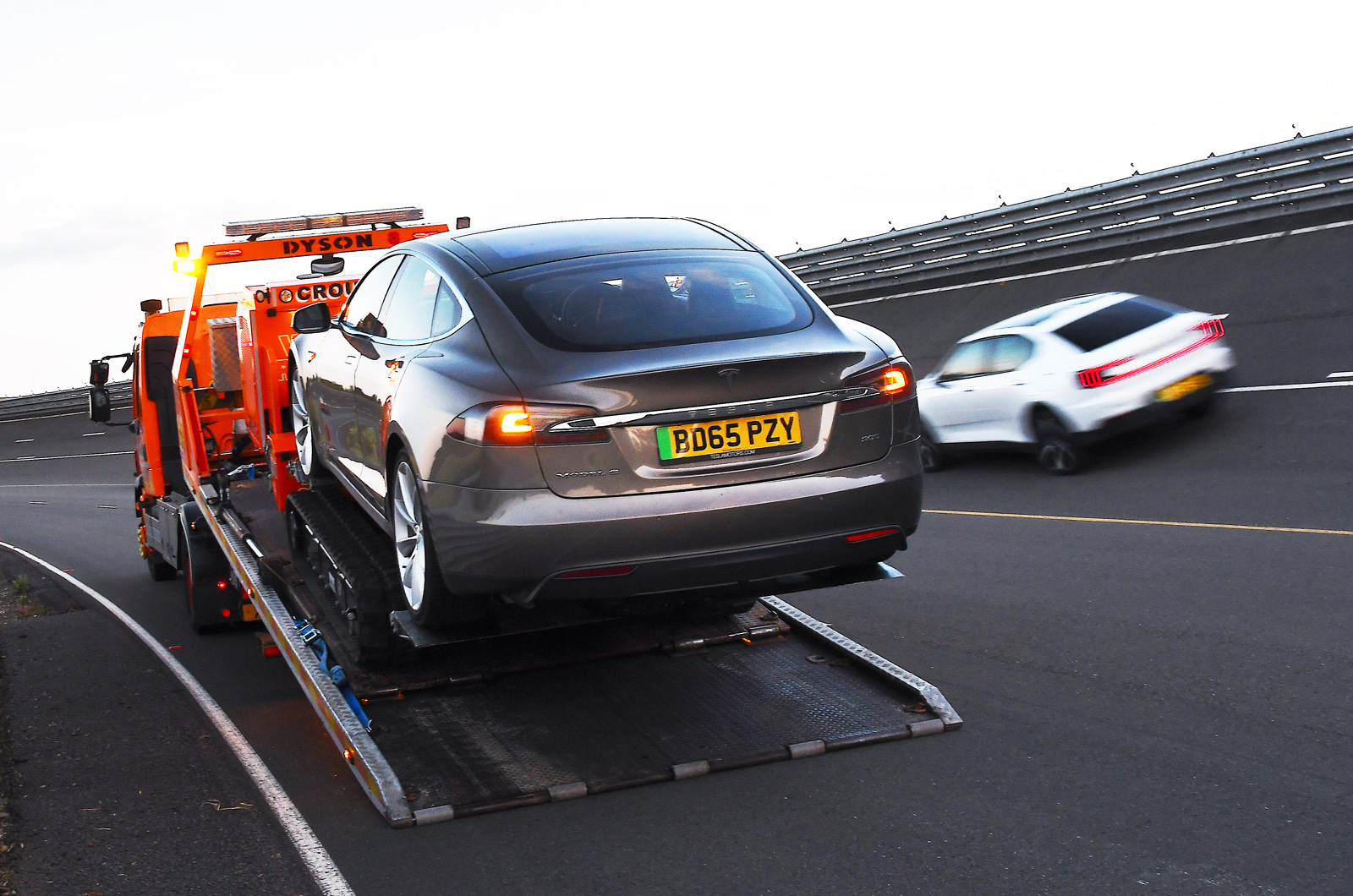 Tesla Model S on back of breakdown truck as Polestar 2 passes