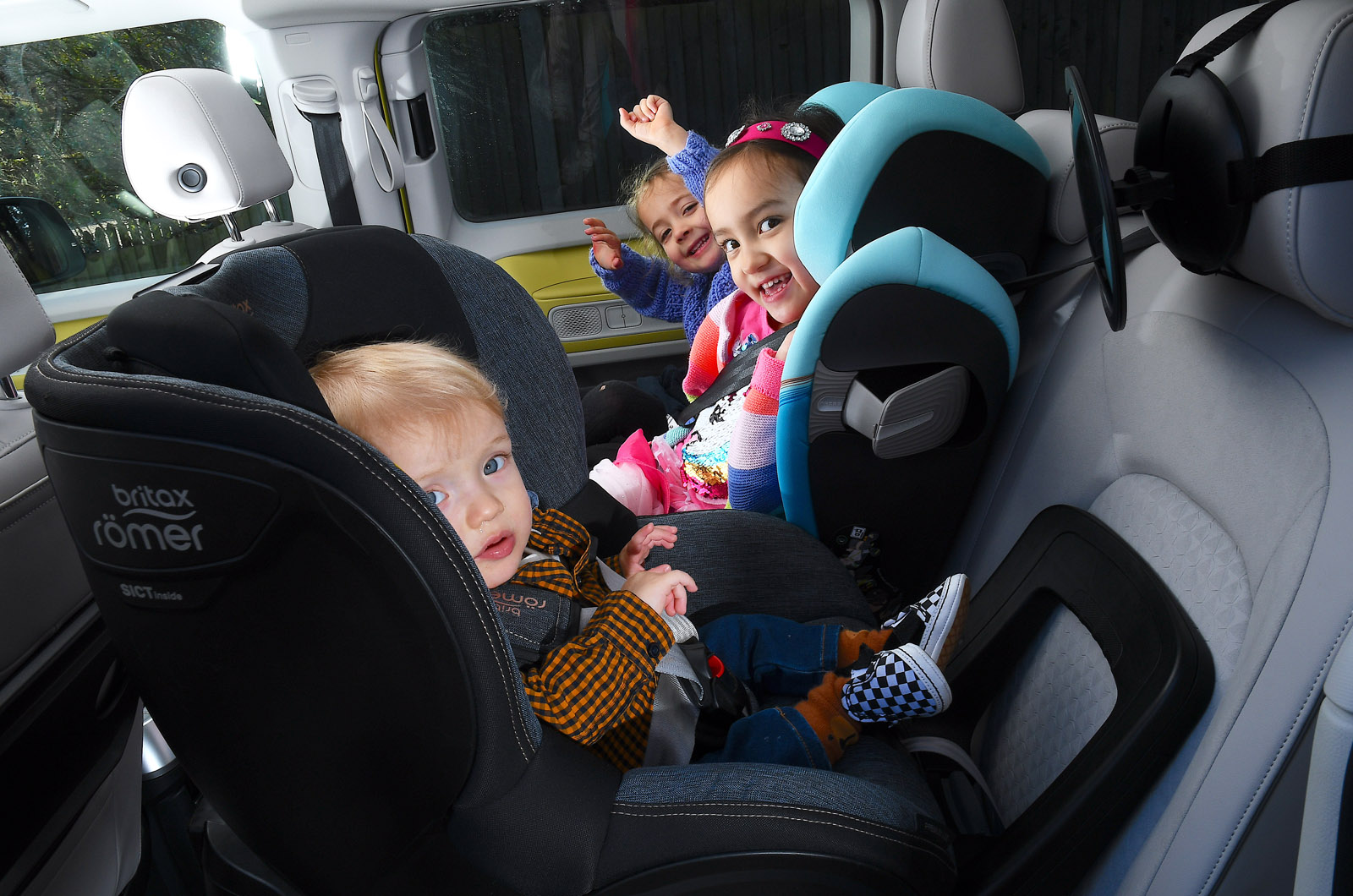 Three children in car child seats - side by side