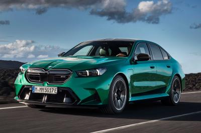 BMW M5 saloon green driving front