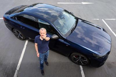 BMW i5 LT from above with person holding penny