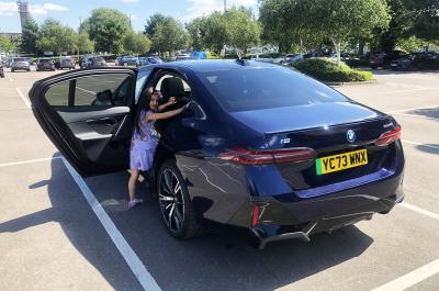 BMW i5 LT with child climbing up into child car seat