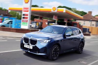 BMW X3 LT driving past petrol station