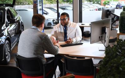 Customer and a salesperson discuss finance options inside a dealership