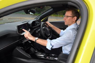 James Tute testing Peugeot E-208 infotainment touchscreen