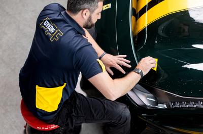 A gyeon technician applies a protective paint film (PPF)