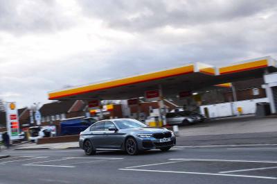 LT BMW 530e driving past petrol station