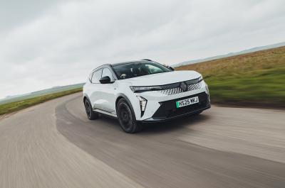 White Renault Scenic E-Tech electric driving on a country road viewed the front three-quarter