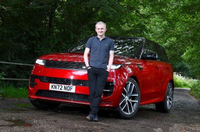 Range Rover Sport LT with person standing in front of it