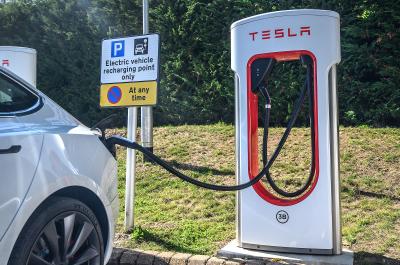 White Tesla Model 3 plugged into a Tesla charger