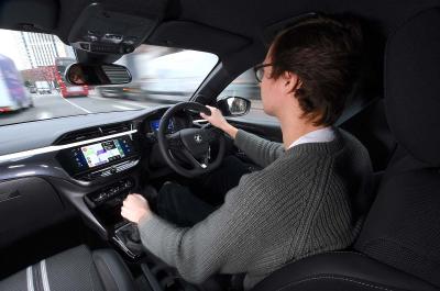 George driving Vauxhall Corsa through city
