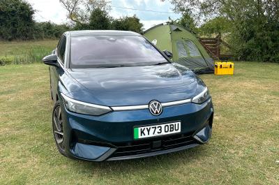 VW ID7 Pro Match, blue, front static in front of tent