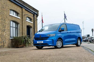 Blue Volkswagen Transporter Panel Van parked in front of a building front three quarter shot