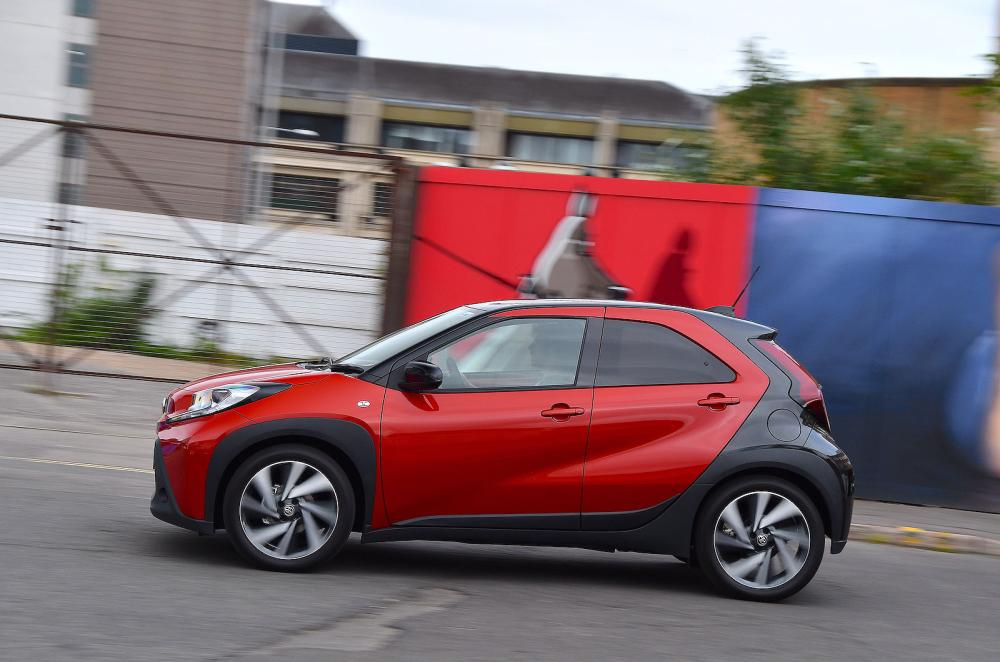 Red Toyota Aygo X left driving
