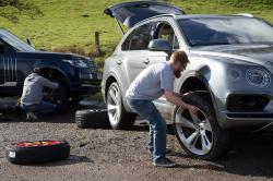 People changing wheels on cars