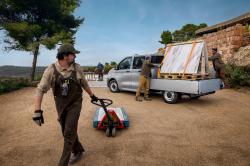 A Volkswagen Transporter Double Cab flatbed with workers securing the payload