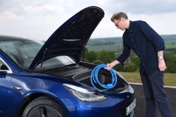 James Tute putting cable into Tesla Model 3 front boot