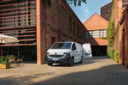 A white Volkswagen Transporter parked next to a building