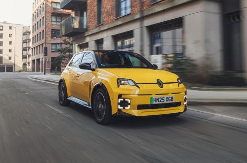 A Pop Yellow Renault 5 driving through the city viewed from the front three quarter